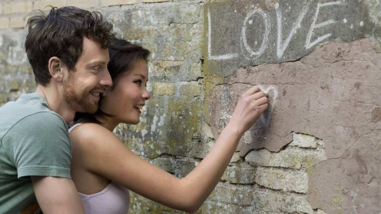Girlfriend writing LOVE on a wall