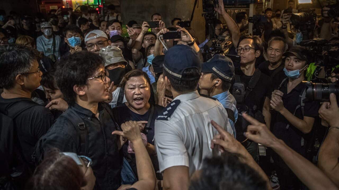 Protesters argue with the police outside a shopping mall during a rally to denounce recent firings at Hong Kong's airline Cathay Pacific.