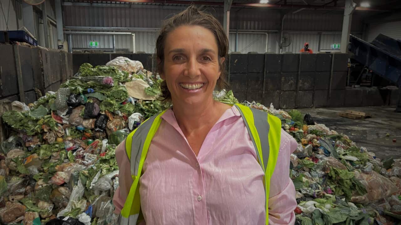 Olympia Yarger standing in front of a pile of vegetable produce food waste