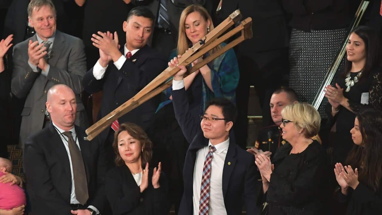 North Korean defector Ji Seong-ho raises his crutches as he is recognized by US President Donald Trump during the State of the Union address