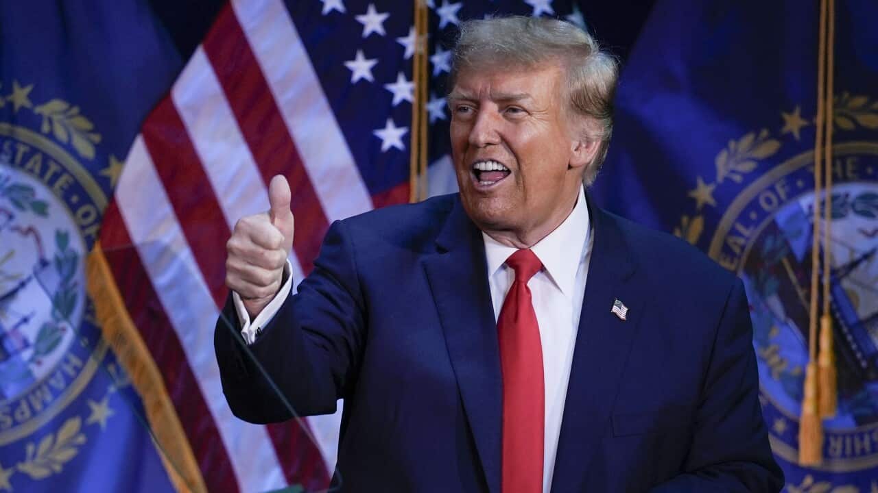 A man in a suit giving the thumbs up