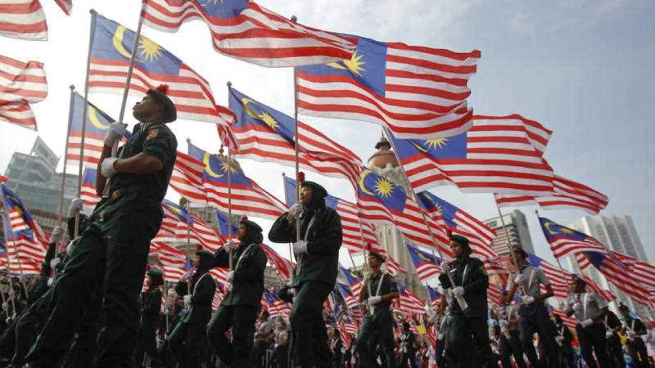 Students carry Malaysian national flags during the 60th National Day celebrations at the Independence Square in Kuala Lumpur, Malaysia