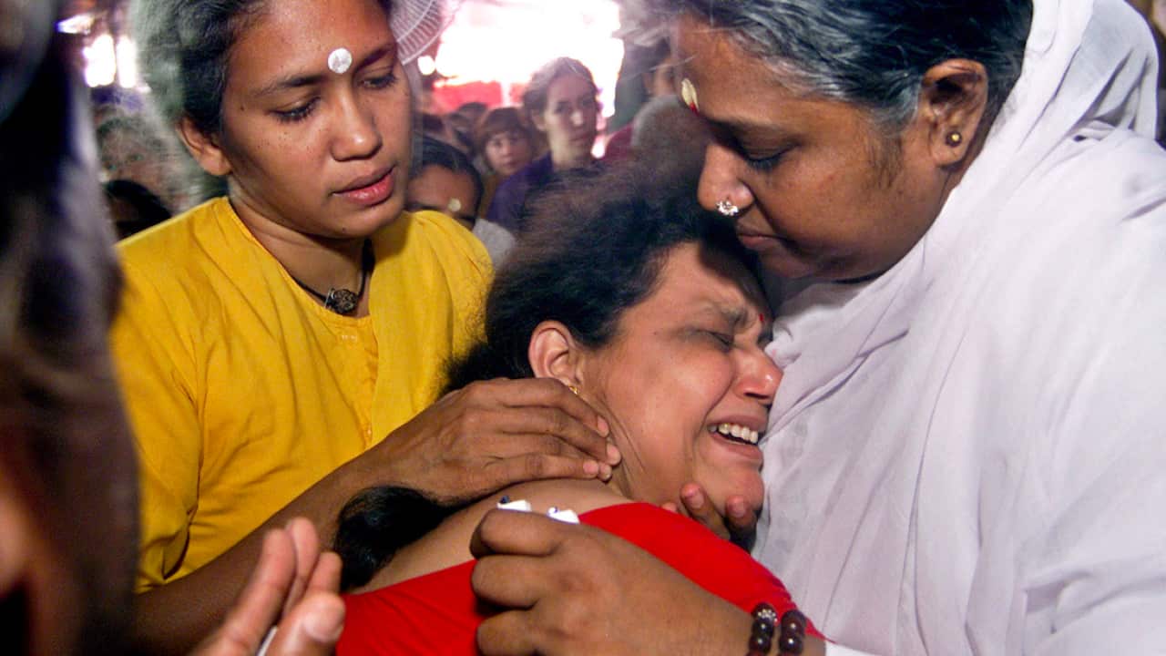 Spiritual leader Mata Amritanandamayi, right, hugs a crying devotee during a spiritual discourse in Bangalore, India.