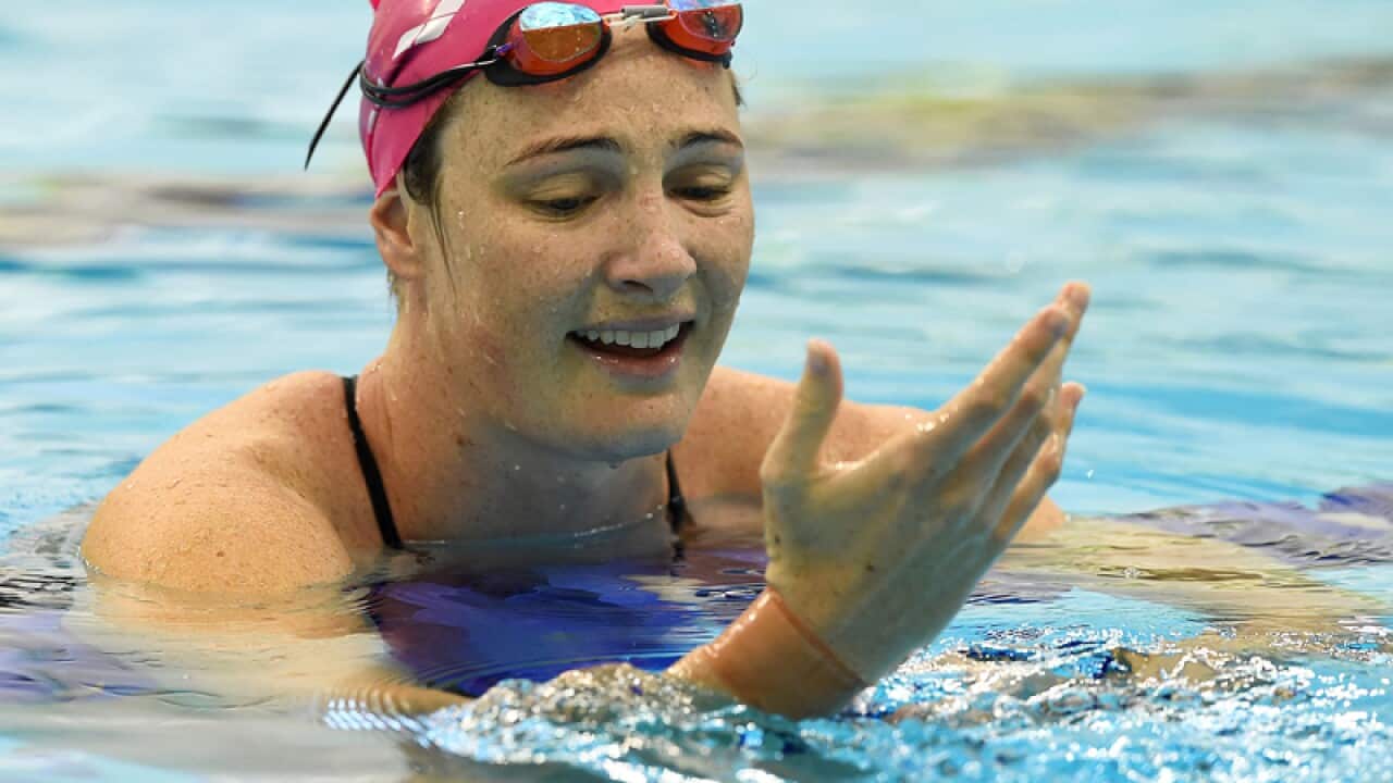 Former world champion Cate Campbell looks at bandaging on her wrist