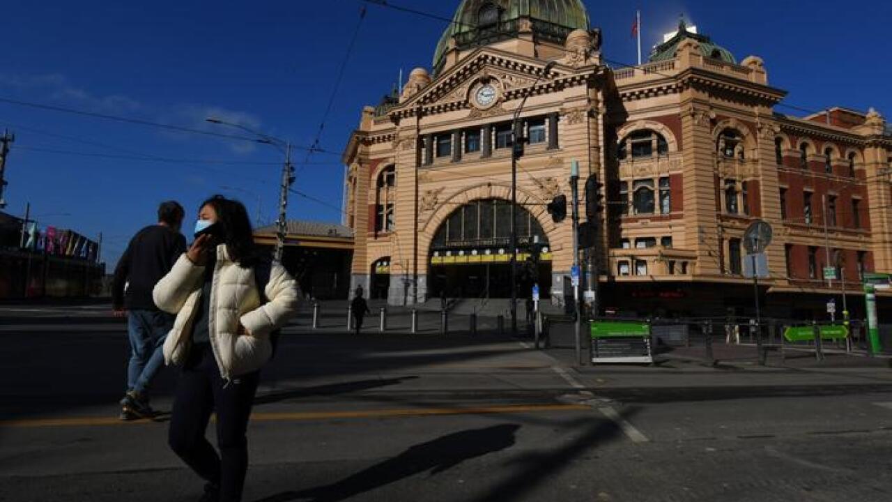A person wearing a face mask is seen outside of Flinders Street Station in Melbourne, 10 August, 2020.