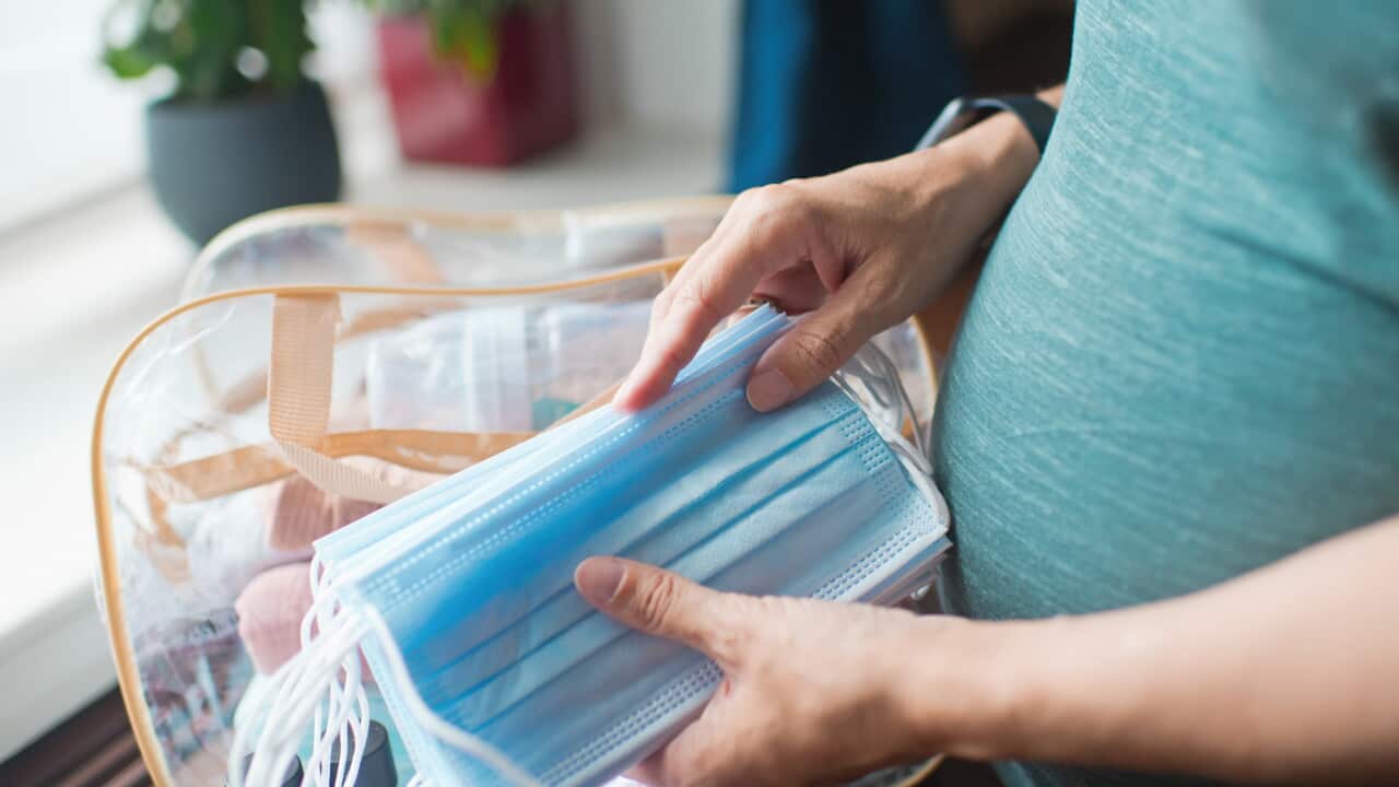 Pregnant woman preparing protective face masks for the hospital for childbirth