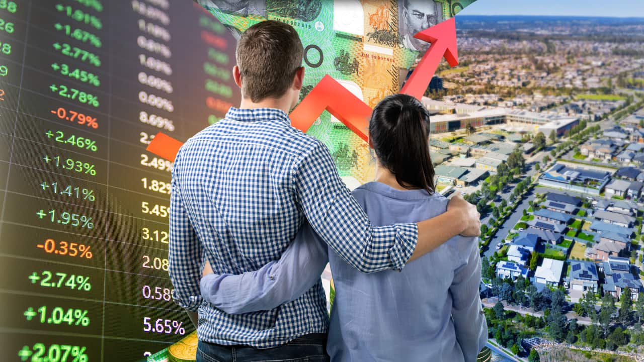 A couple is seen from behind as they look out at composite scene of residential property and share market prices.
