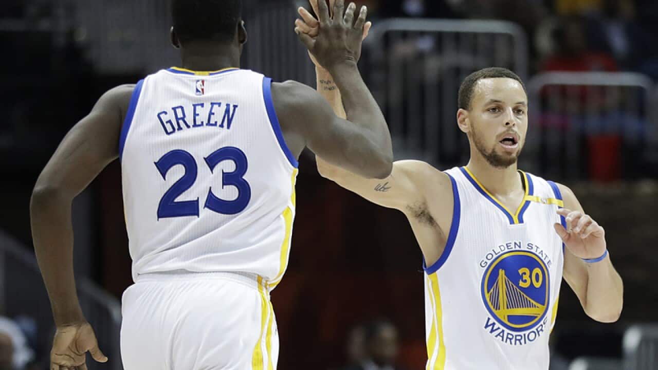 Golden State Warriors' Stephen Curry (R) and Draymond Green