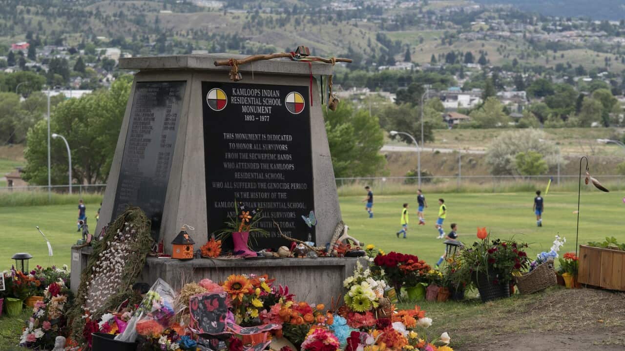 Children play football near a memorial outside the residential school in Kamloops earlier this month.