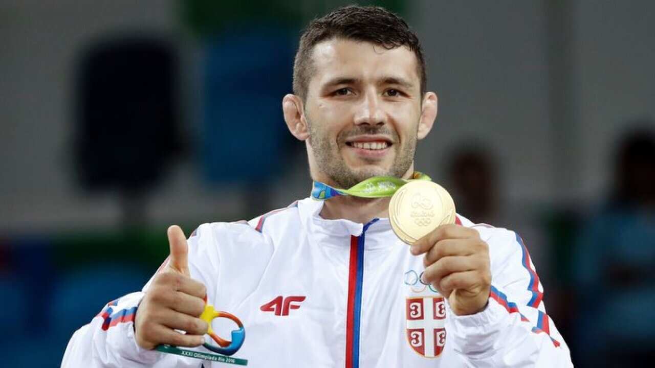 Serbia's Davor Stefanek celebrates on the podium after winning the gold medal in the men's 66kg greco-roman wrestling event at Rio 2016 Olympic Games