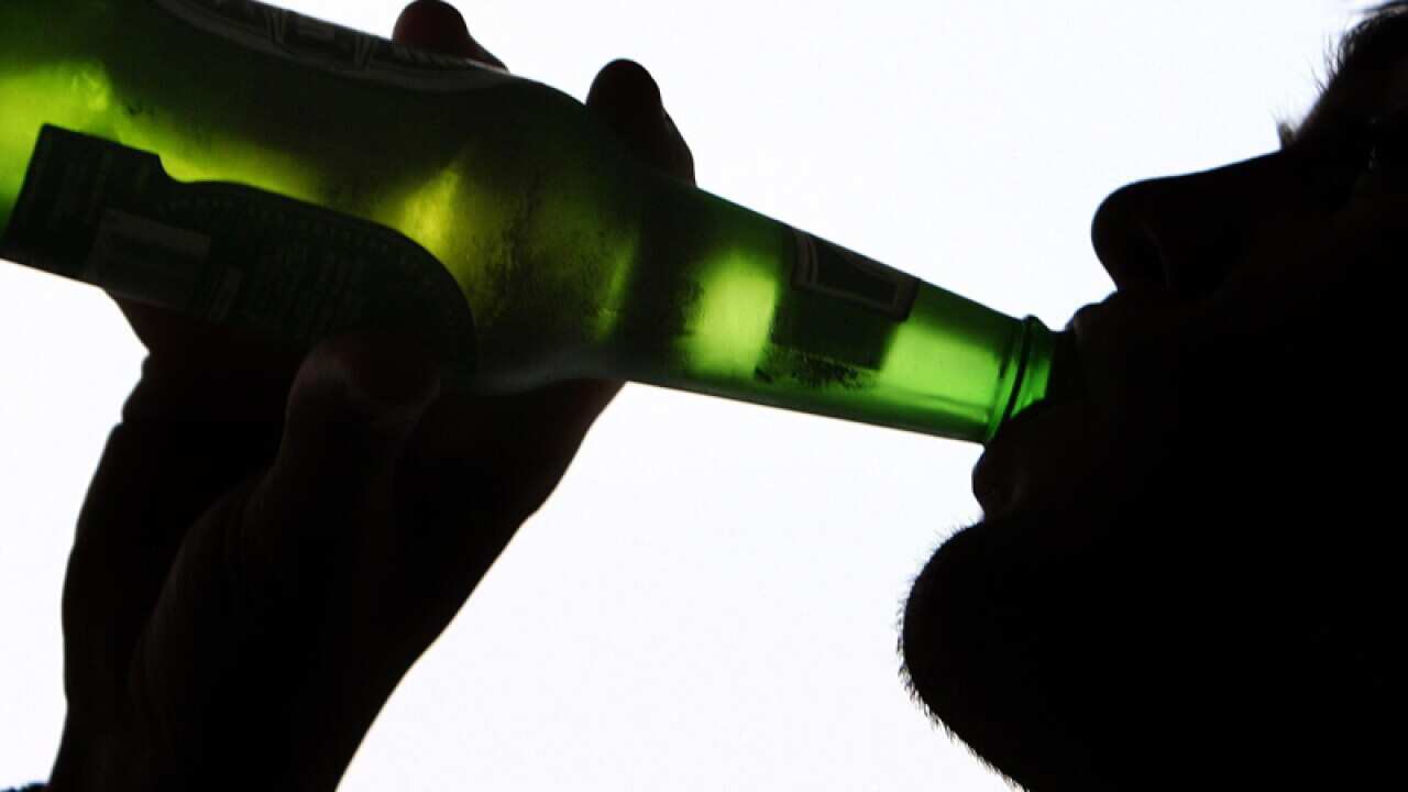 A person drinking a bottle of beer