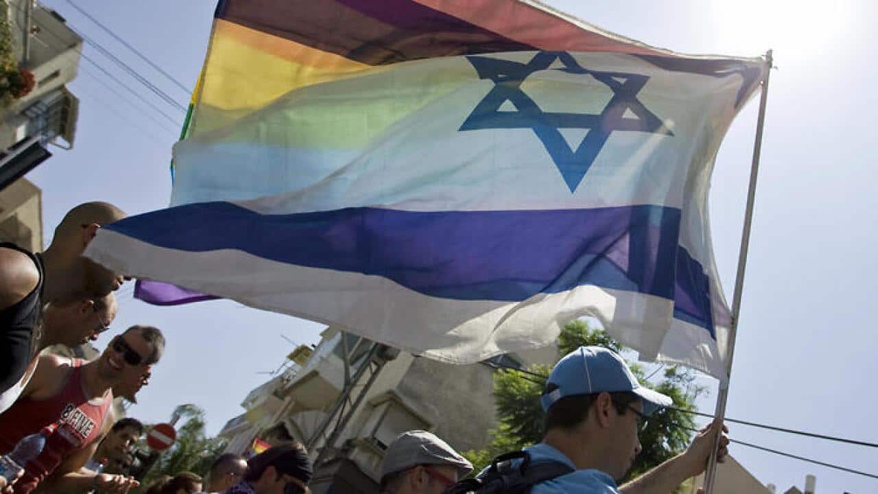 An Israeli man holds up a rainbow flag