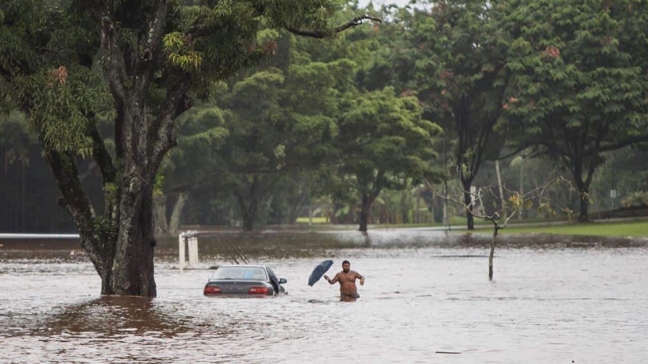 A man and his stranded car are caught in excessive rain from Hurricane Lane in Hilo, Hawaii.