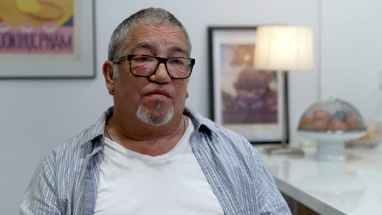 Simon Ross facing the camera, sitting in his home.