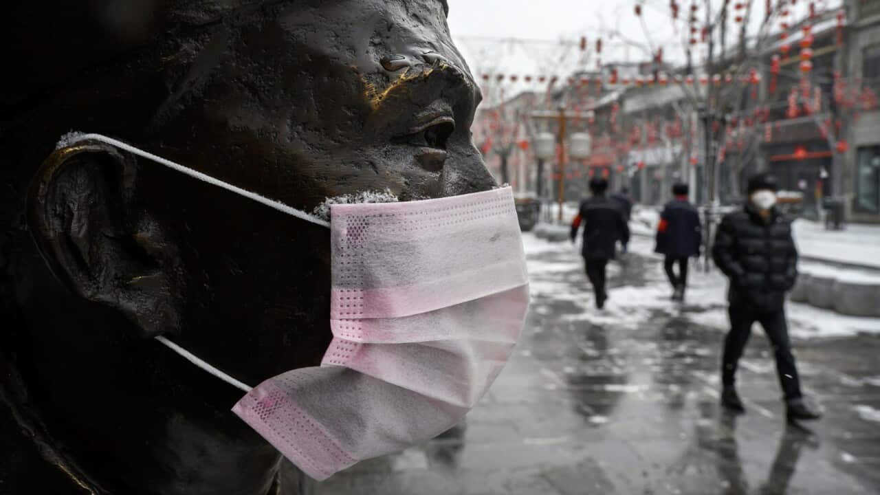 A protective mask on a statue outside a restaurant in Beijing