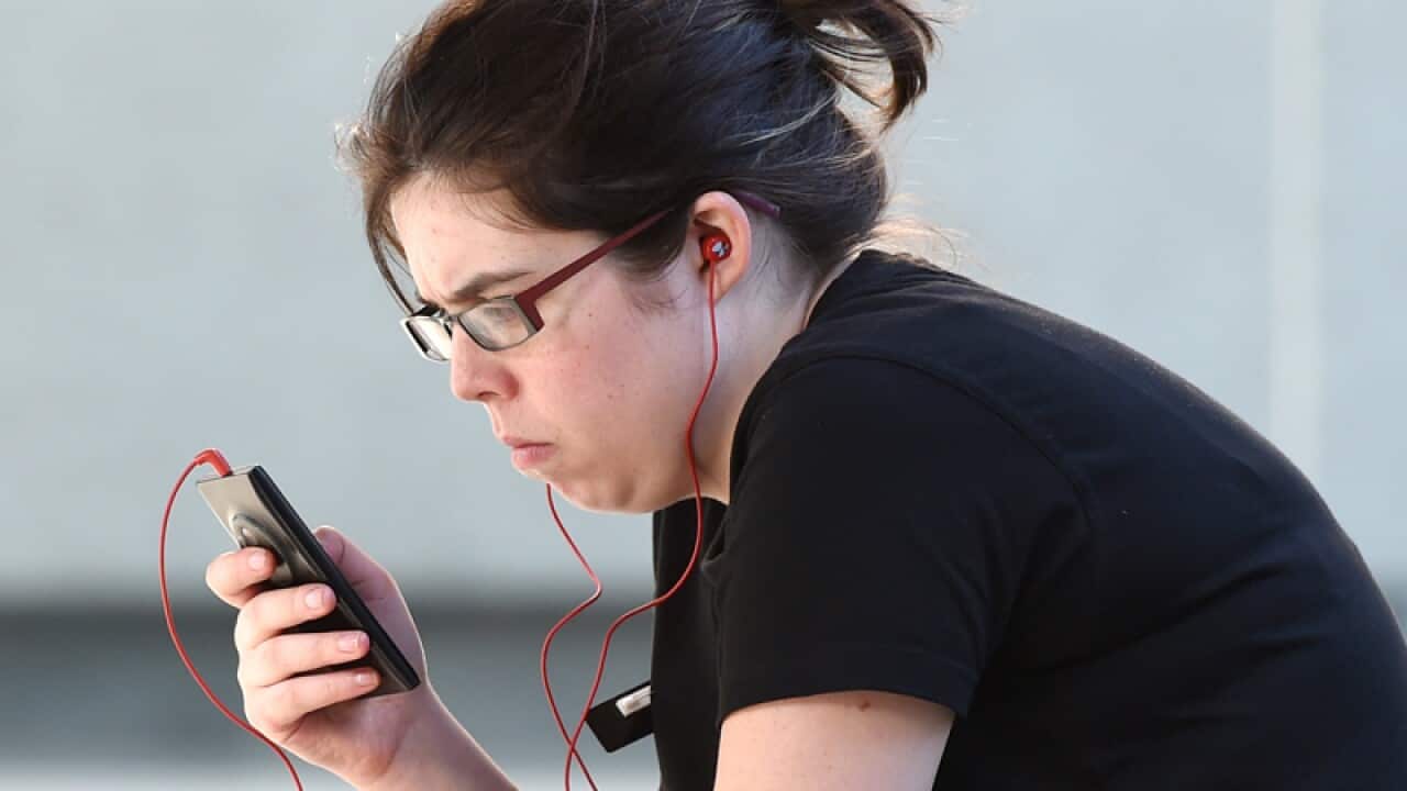 A woman looks at her mobile phone