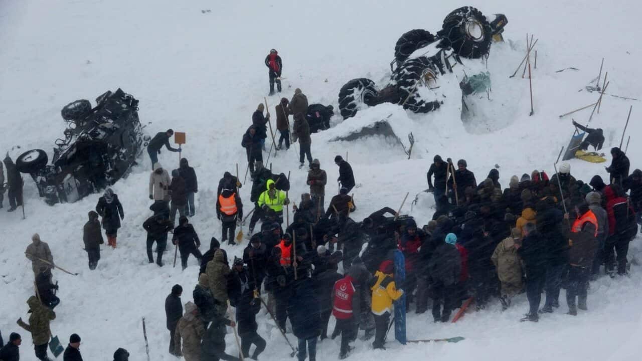 Emergency service members work in the snow around overturned vehicles, near the town of Bahcesaray, Van province, eastern Turkey.