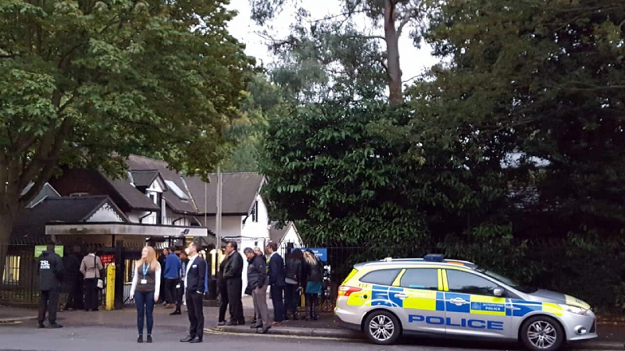 Police and evacuated visitors stand outside London Zoo