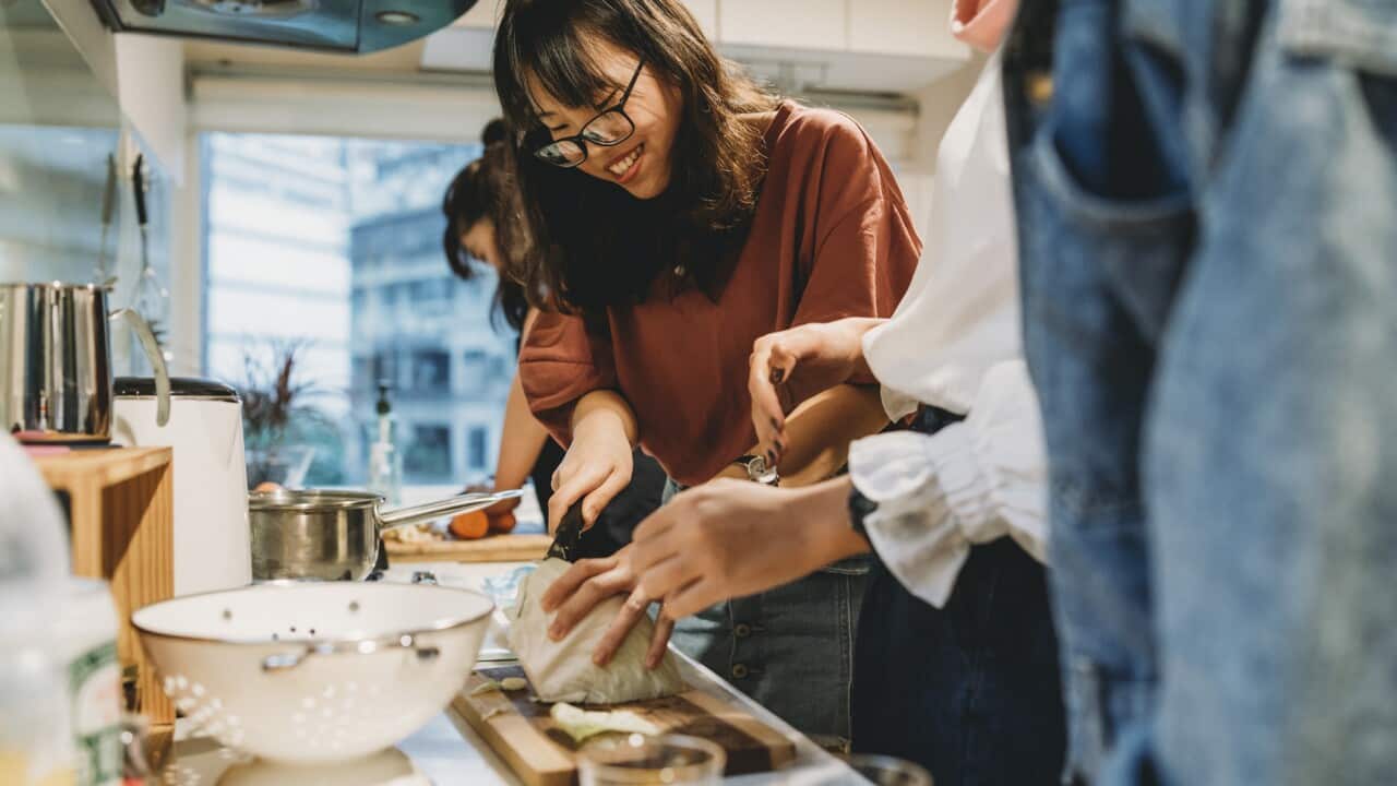 Group of friends preparing dinner together in the kitchen