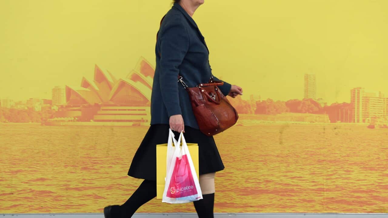 A shopper carries a bag from a retail store in Sydney