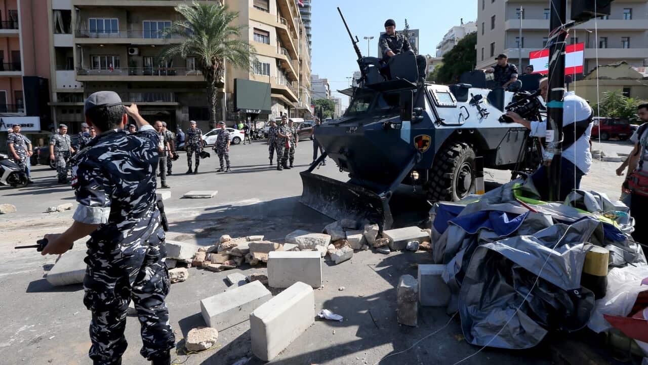 Lebanese policemen patrol as anti-government protestors begin removing their tents in Beirut
