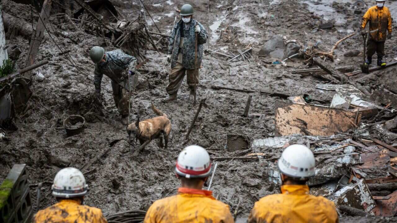 Japan Self-Defence Force (JSDF) soldiers with a search dog search for missing people at the site of a landslide on 4 July 2021 in Atami, Shizuoka, Japan.