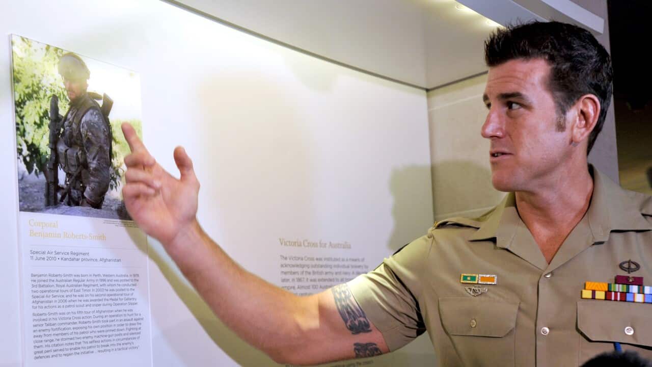 Ben Roberts-Smith observing a display honouring him at the Australian War Memorial.