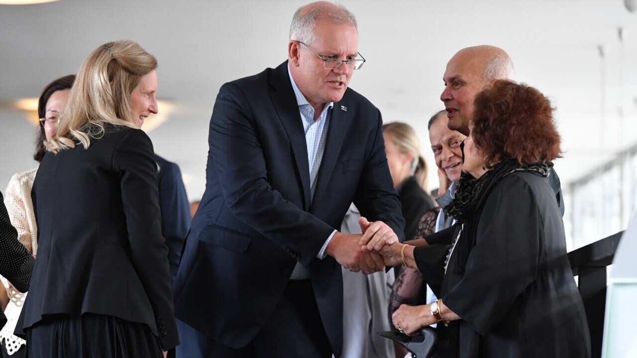 Scott Morrison shakes a woman's hand