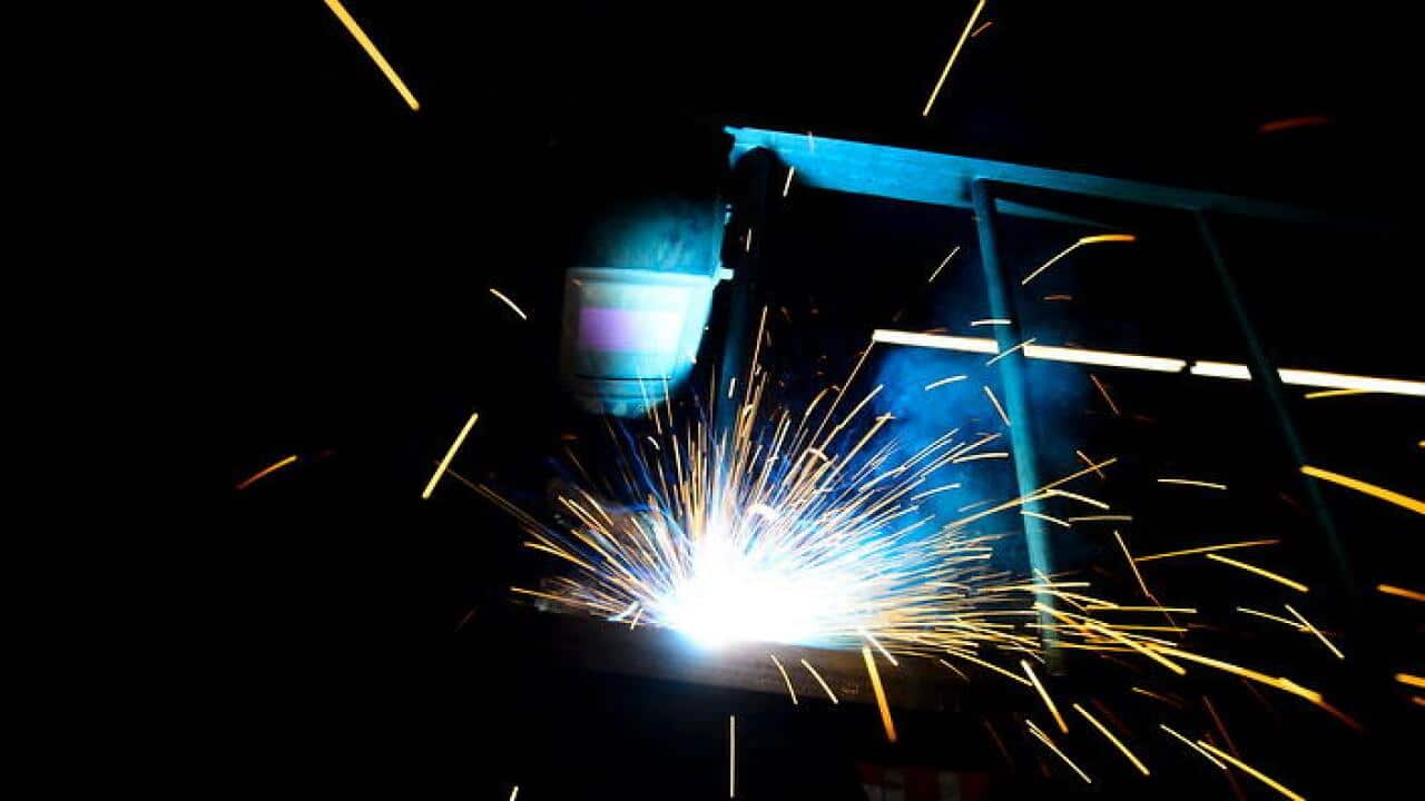 A welder fabricates a steel structure at an iron works facility in Ottawa, Ontario (AAP)