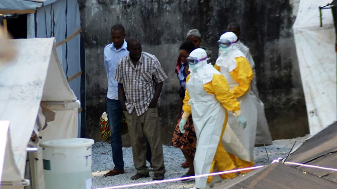 Health workers wearing protective suits walk in an isolation centre