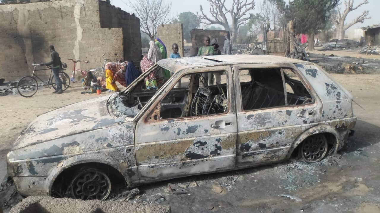 Children gather around a burnt out car following an attack by Boko Haram in Dalori village 5 kilometers from Maiduguri, Nigeria.