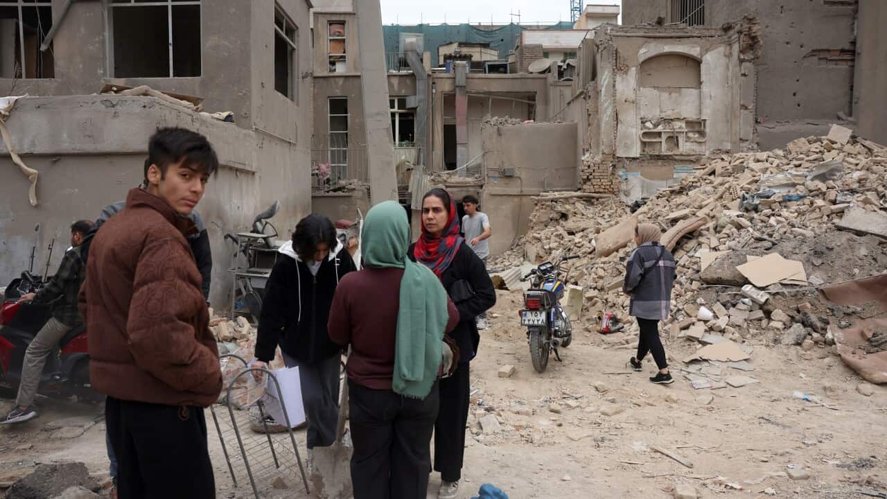 Iranians collect their belongings from damaged residential buildings in southern Tehran