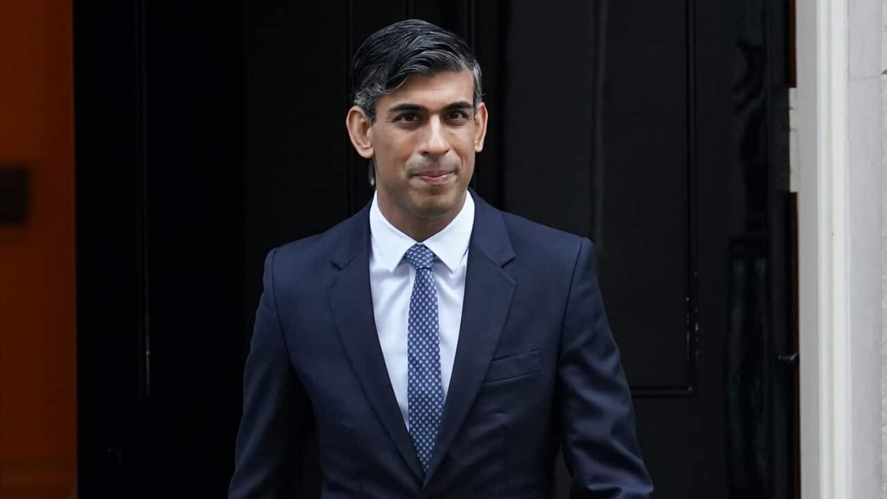 Man walks out the door with a folder in his hand