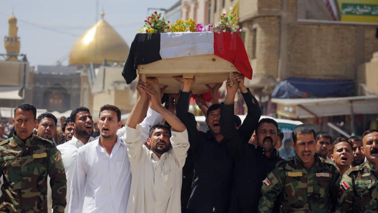 Mourners carrying a coffin of a victim killed in a car bomb in Najaf