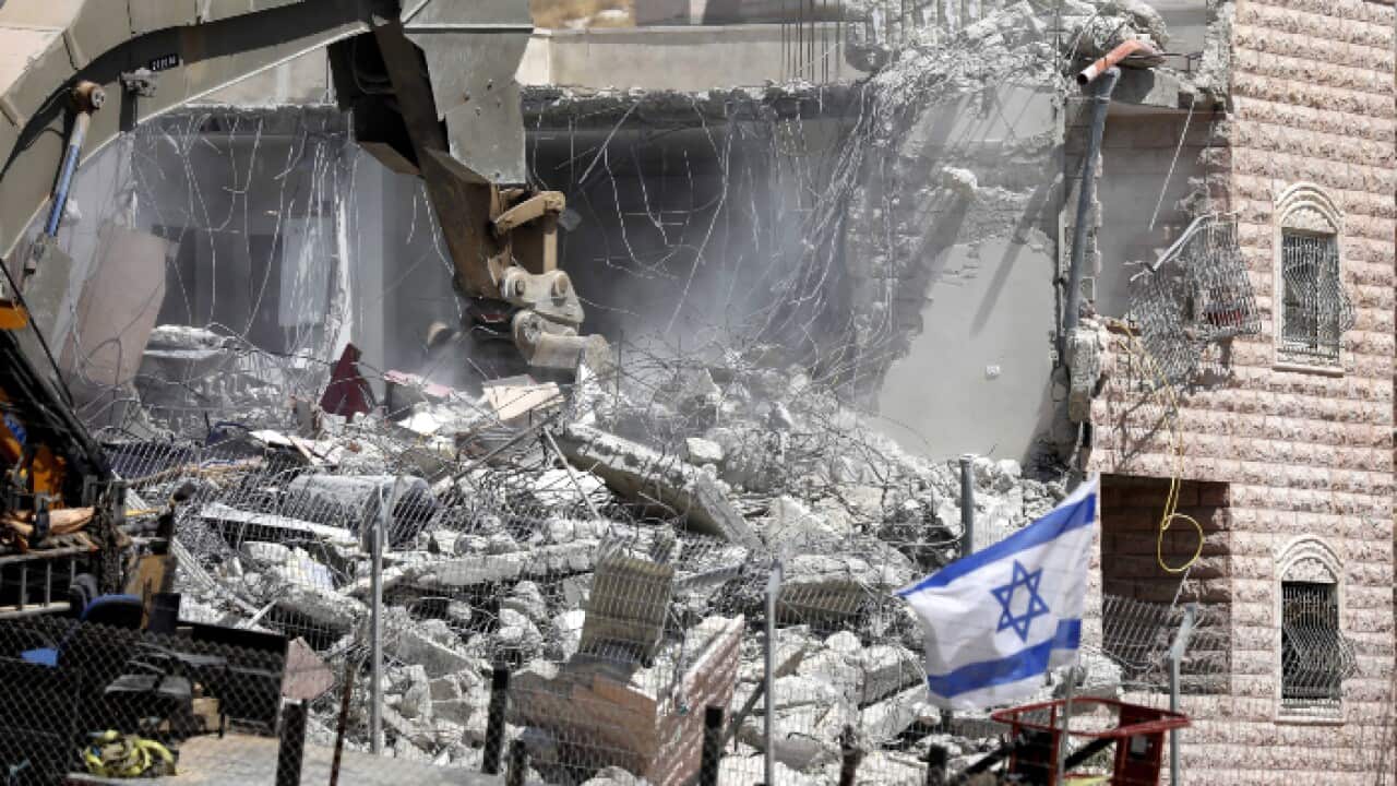 n Israeli army excavator machine demolishes a building in the Palestinian village of Sur Baher, in East Jerusalem