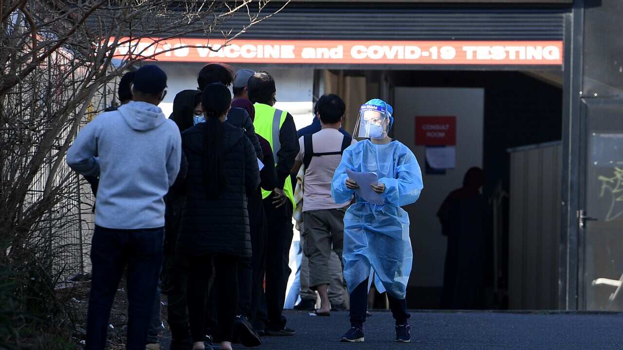 People are seen waiting to receive a COVID-19 test in Lakemba, southwest of Sydney, Friday, August 20, 2021.