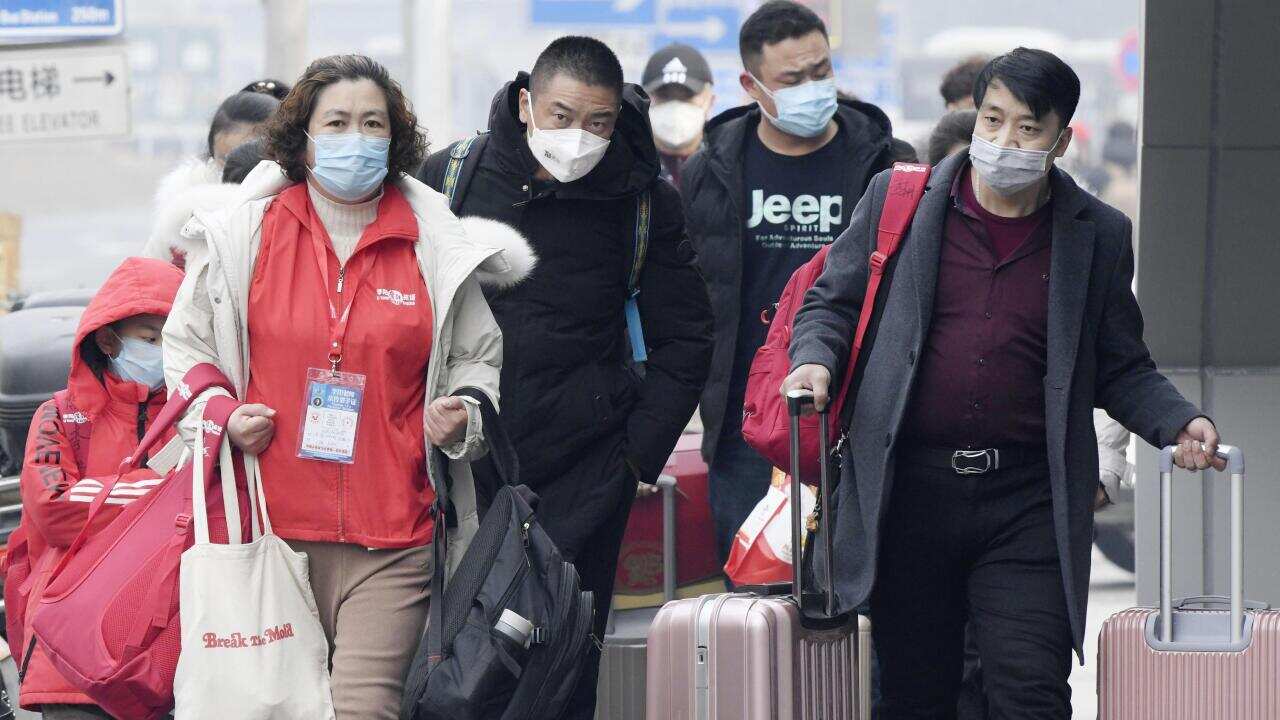 People wear masks in Beijing on Jan. 26, 2020, amid the spread of pneumonia caused by a new coronavirus in the central Chinese city of Wuhan. (Kyodo via AP Images) ==Kyodo