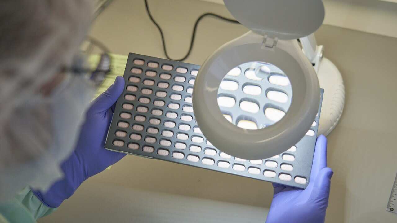 A Pfizer lab technician visually inspects Paxlovid tablet samples in Freiburg, Germany (Suppled - Pfizer).