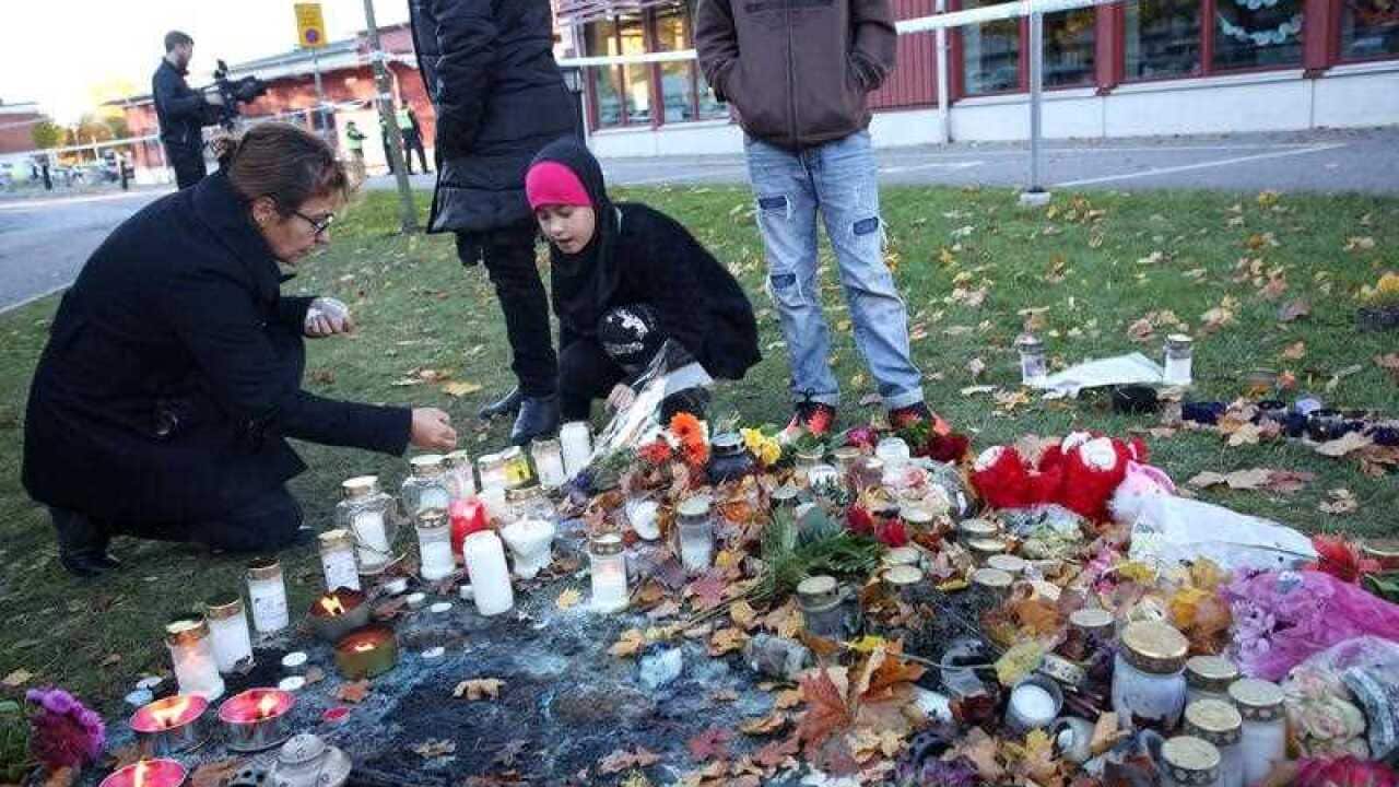 People light candles in tribute to the victims of an attack, outside the Kronan school in Trollhattan,