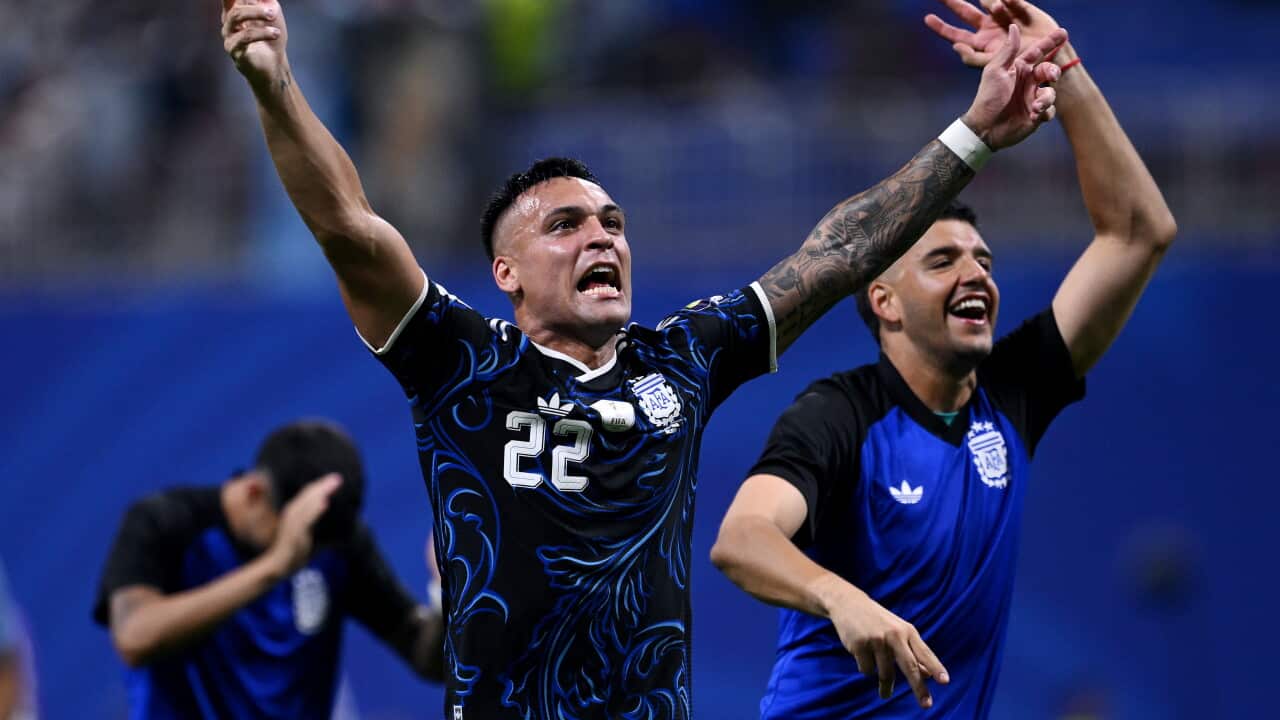 An Argentine football player with arms stretched out in celebration