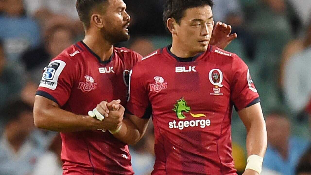 Karmichael Hunt of the Reds shakes hands with team mate Ayumu Goromaru