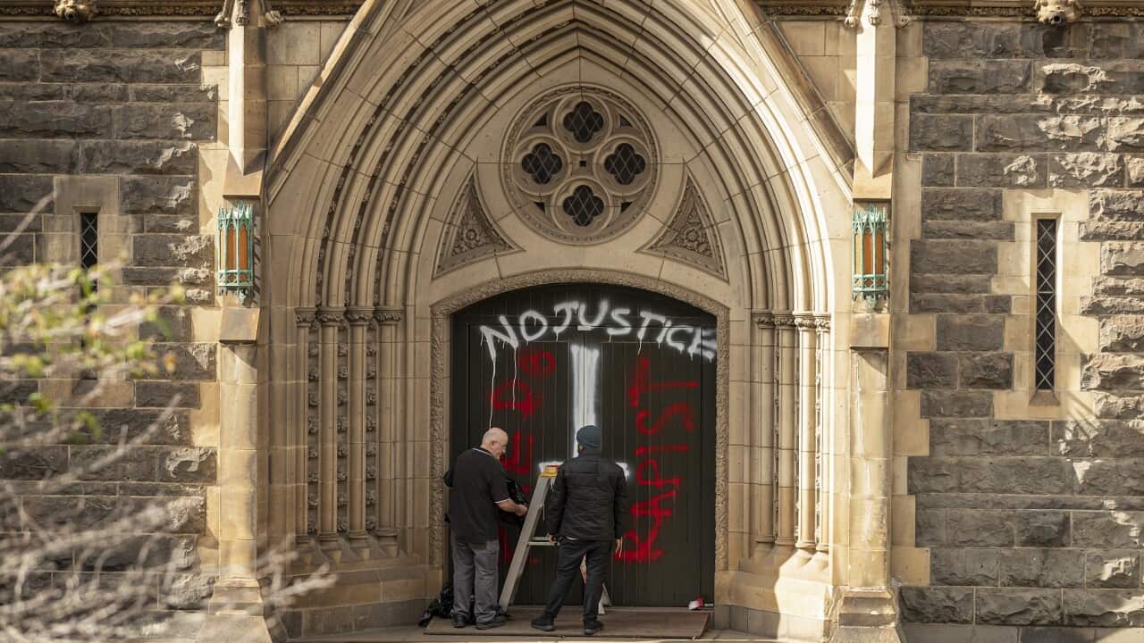 Workers cover graffiti at St Patrick’s Cathedral in Melbourne