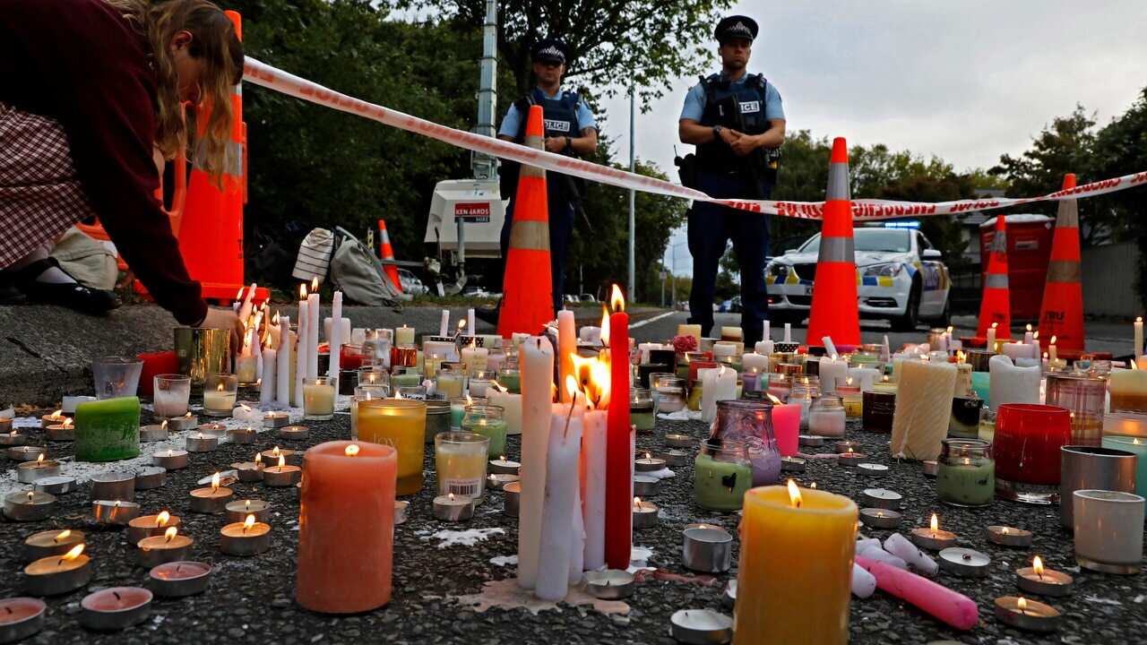 A student lights candles during a vigil to commemorate victims of the Christchurch terror attack.