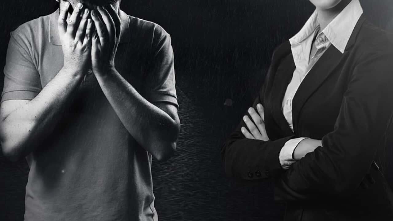 Man covering his face next to professional woman