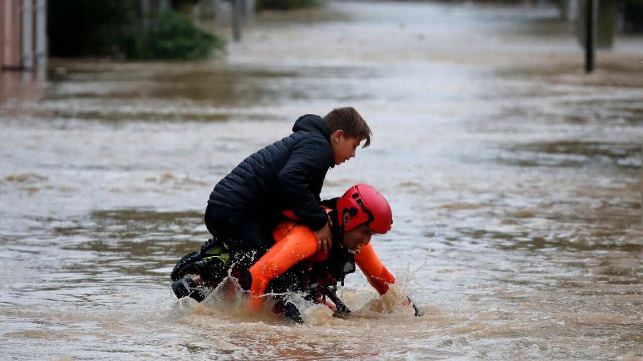 A French firefighter carries a child during rescue operations after floods hit in southwes France.