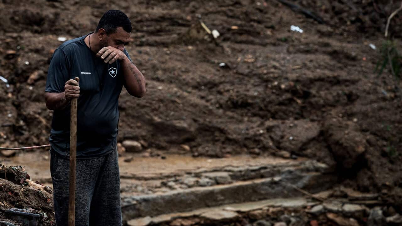 A Brazilian man has an emotional moment as he looks for survivors after a mudslide in Petropolis, Brazil.