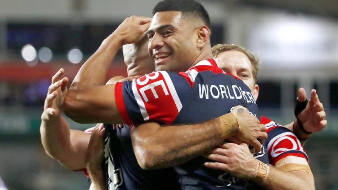 Daniel Tupou of the Roosters (r) embraces teammate Blake Ferguson.