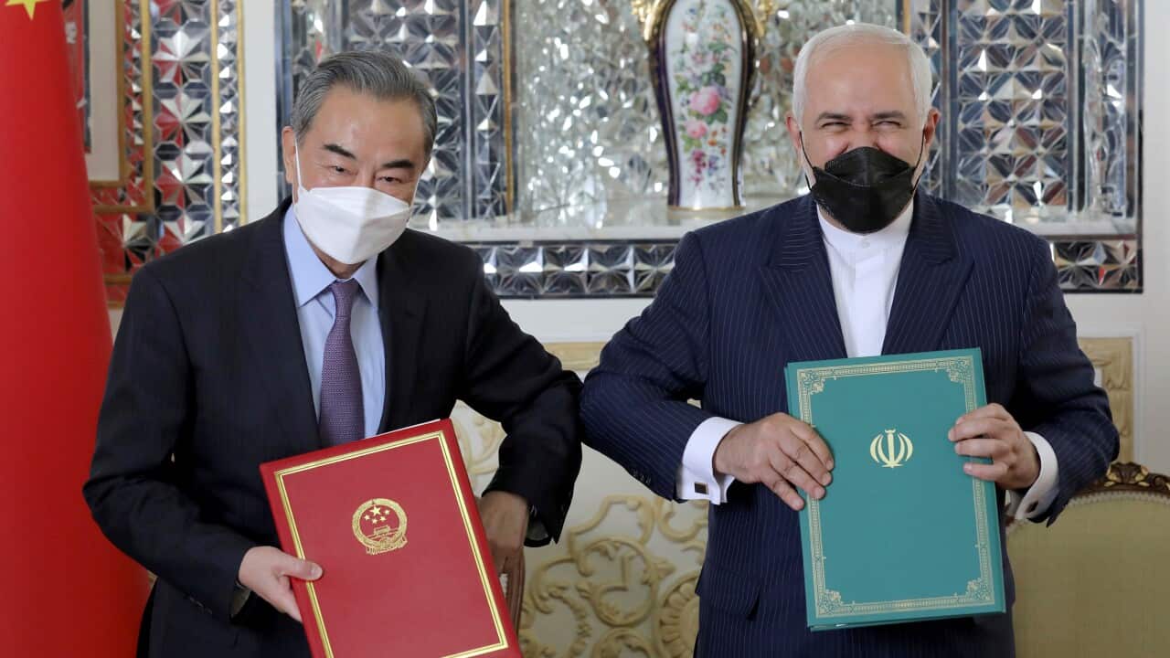 Iranian Foreign Minister Mohammad Javad Zarif, right, and his Chinese counterpart Wang Yi, pose for photos after the ceremony of signing documents, in Tehran, Iran, Saturday, March 27