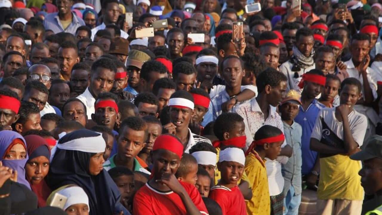 Angry protesters gather near the scene of a truck bomb attack