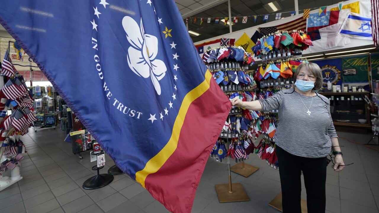 Brenda McIntyre, a co-owner of A Complete Flag Source store in Jackson, Mississippi shows off the magnolia-centered banner.